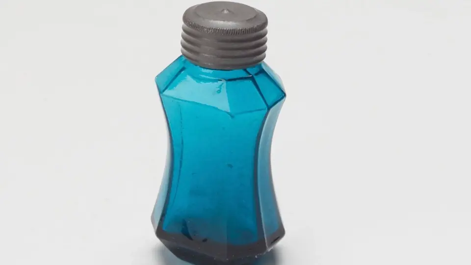 Een parfumflacon bij het raam in het daglicht